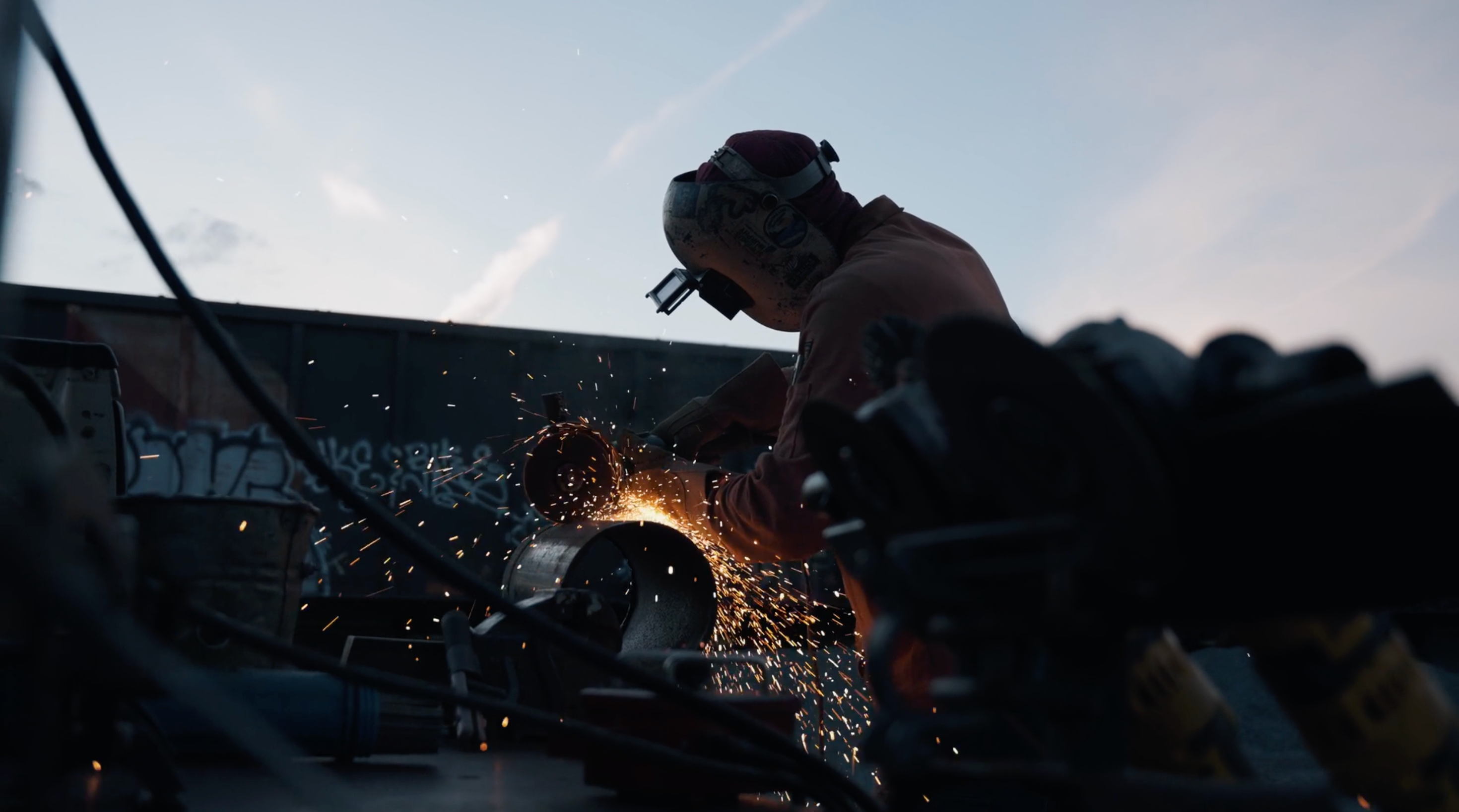 A welder using a welding torch with sparks in a workshop setting