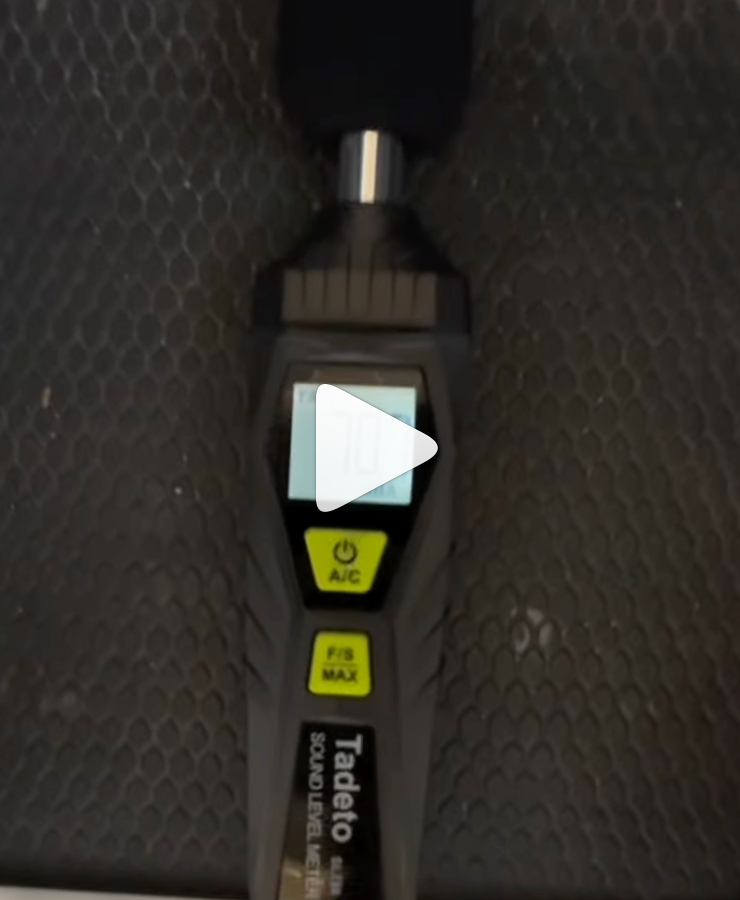 Tadeo brand decibel level meter on a textured black surface