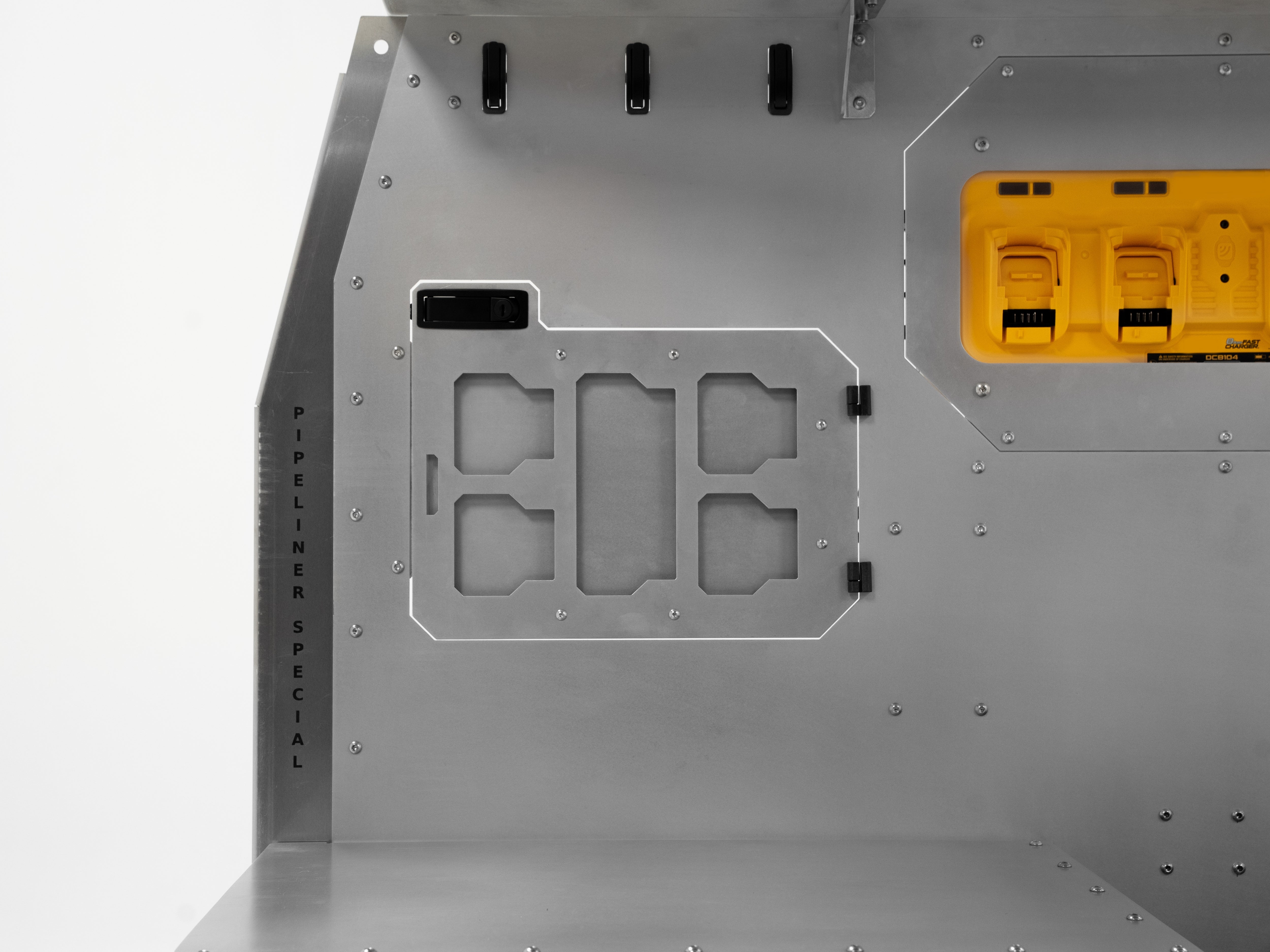 Rear wall of The Pipeliner Special aluminum storage system with integrated yellow power outlets.